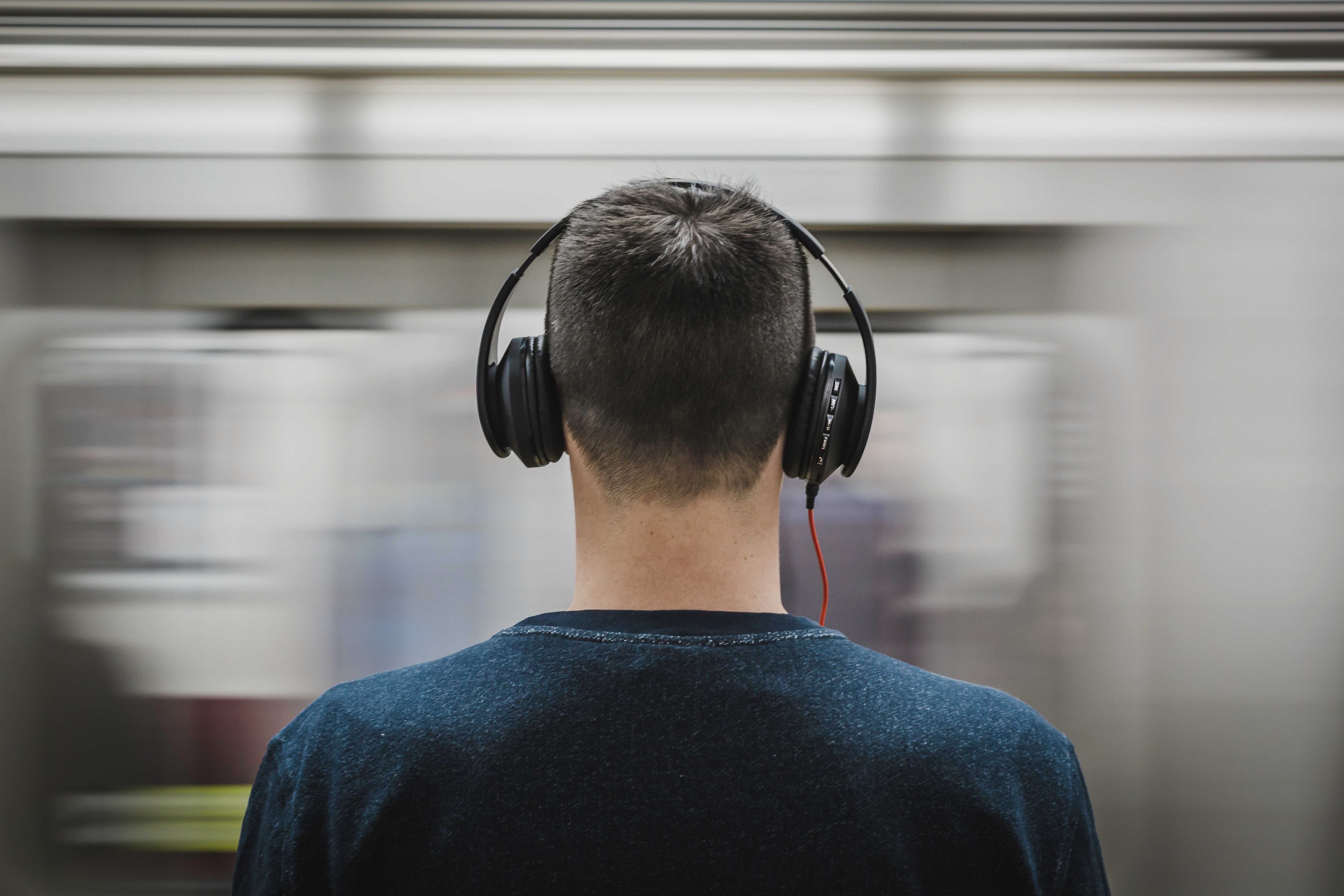 Man with noise cancelling headphones in metro station