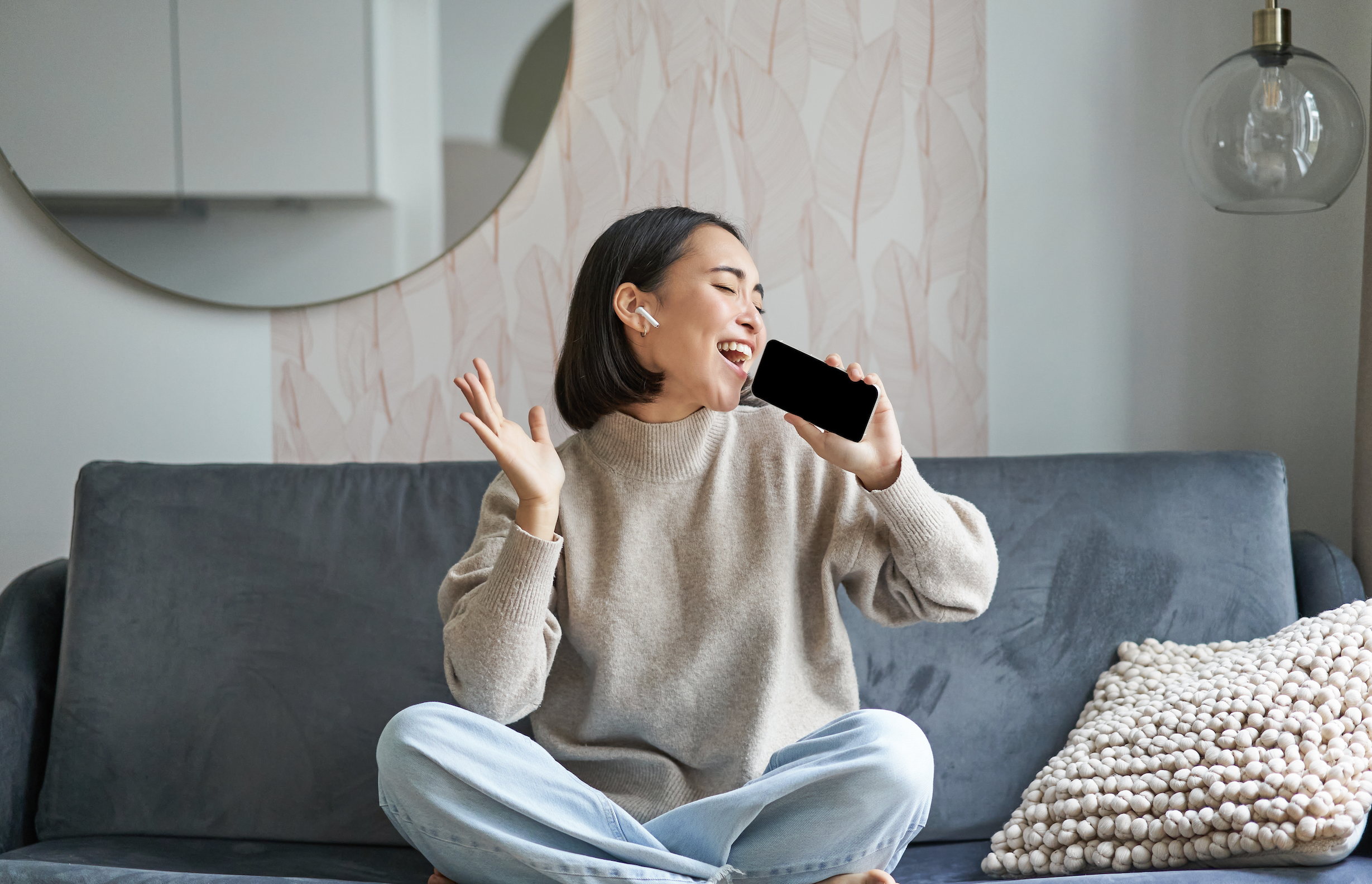 A girl singing on the phone, with a voice isolation app filtering out background noise for clearer sound.
